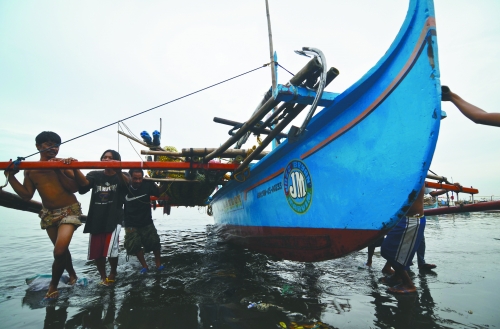 當?shù)貢r間8月10日，馬尼拉海域，漏油事故附近居民開始清理海灘上的油污